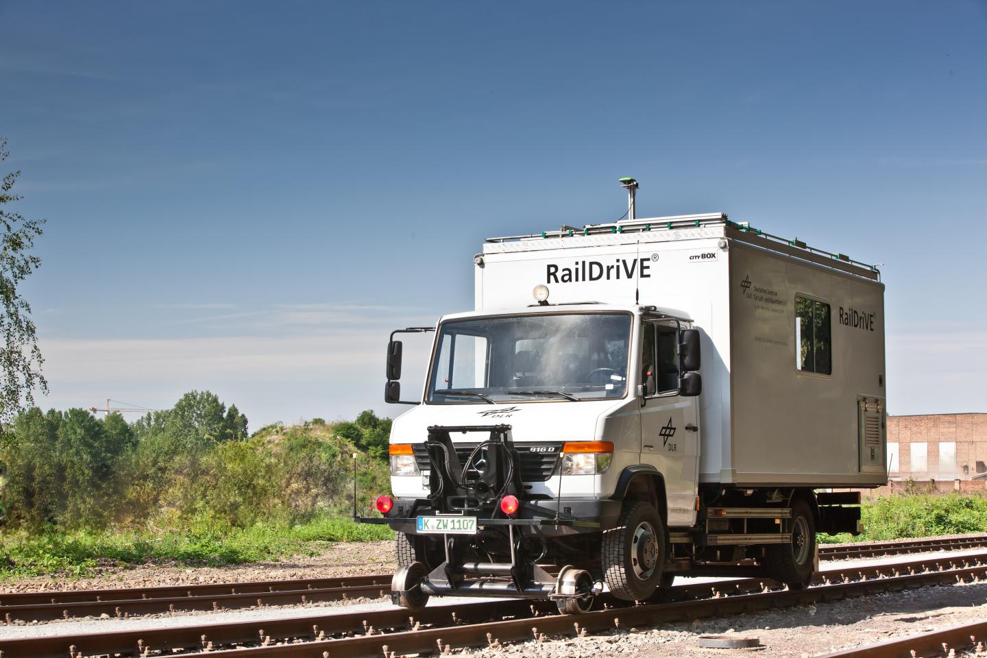 Zweiwegefahrzeug RailDriVE - es meldet seine Annäherung an den Bahnübergang über Rail2X